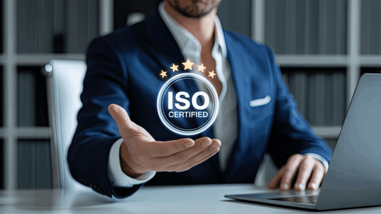 Un professionista a lavoro davanti a un PC mostra sospeso in una mano un ologramma tondo che simboleggia una certificazione ISO.